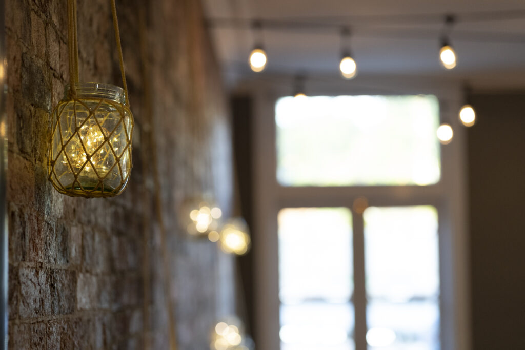 Candlelit reception room with exposed brick walls at Transcontinental Hotel