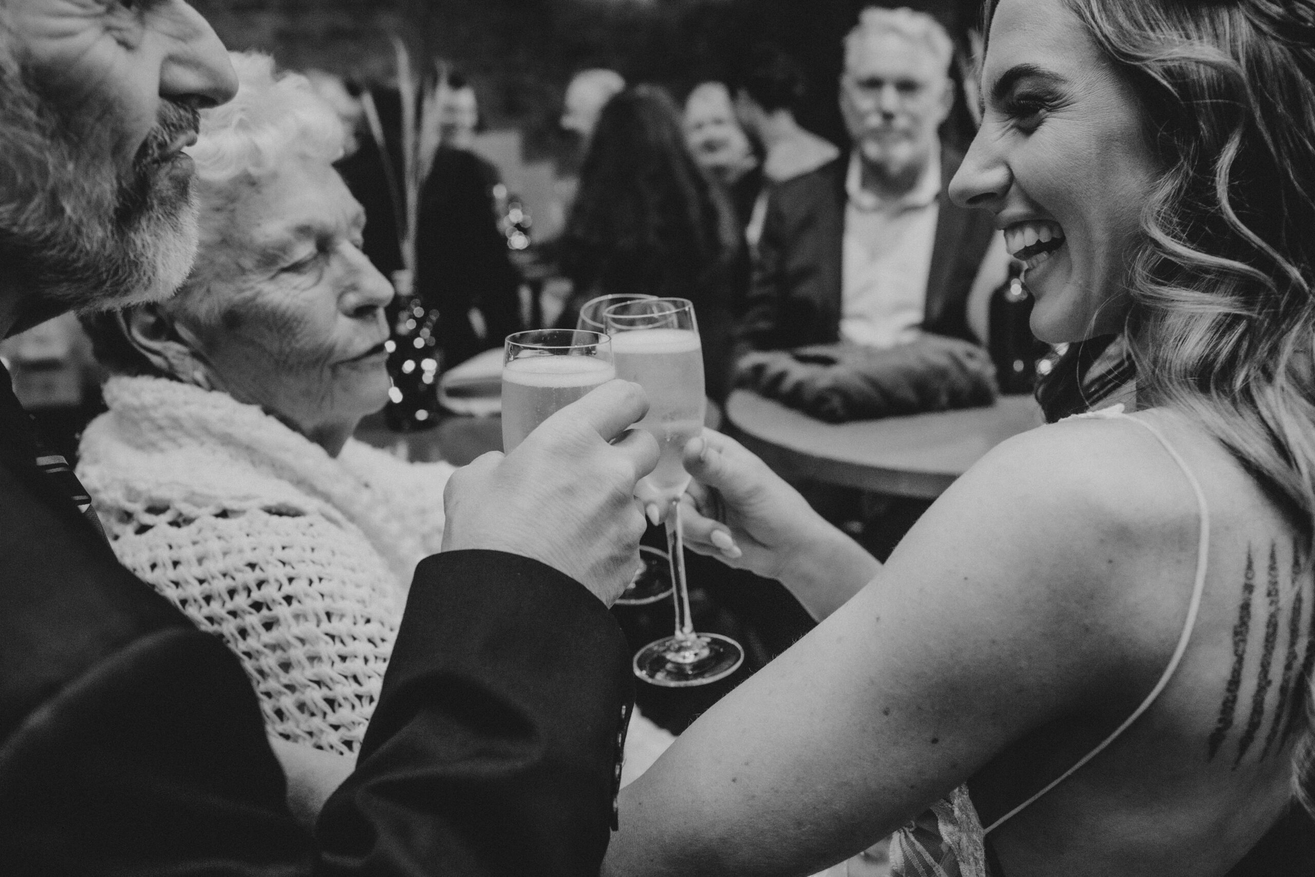 Wedding guests mingling with drinks before an evening reception begins