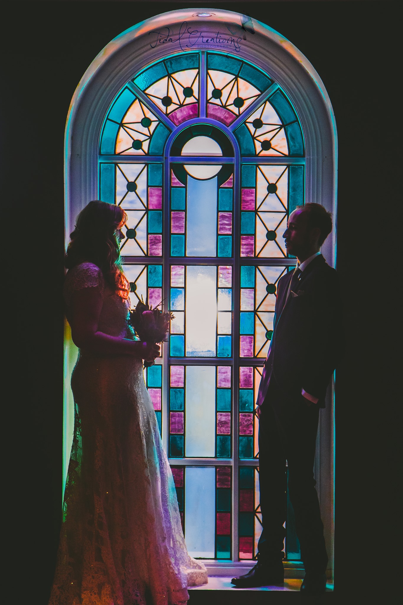 Stained glass window details adding character to an evening wedding celebration