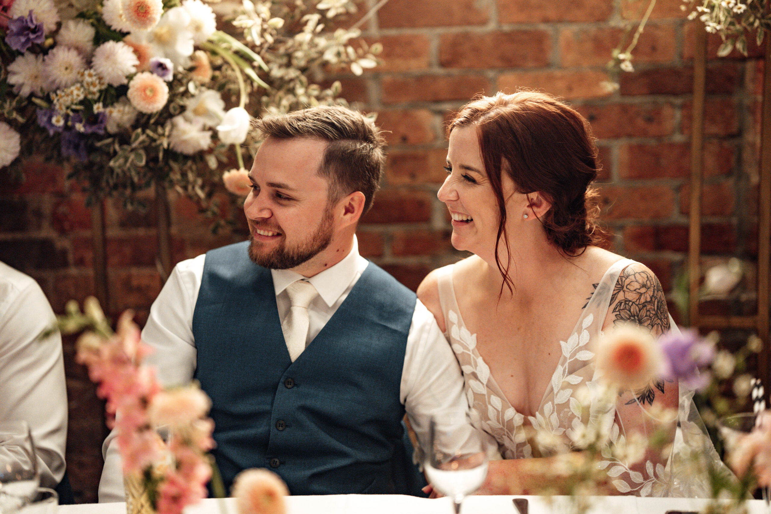 Wedding speech moment surrounded by warm brick interiors and seated guest