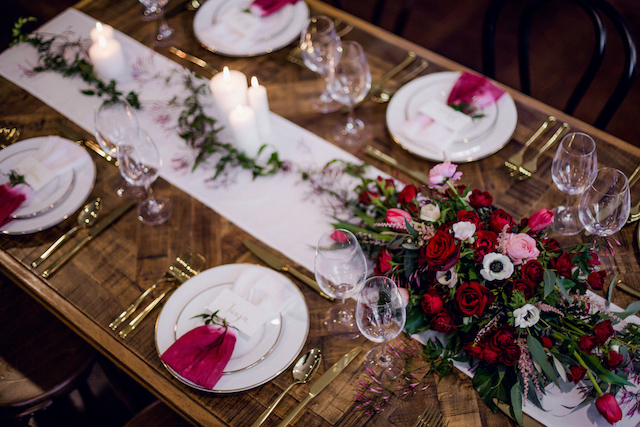 Bridal table styled with olive foliage and burgundy accents for a timeless wedding look