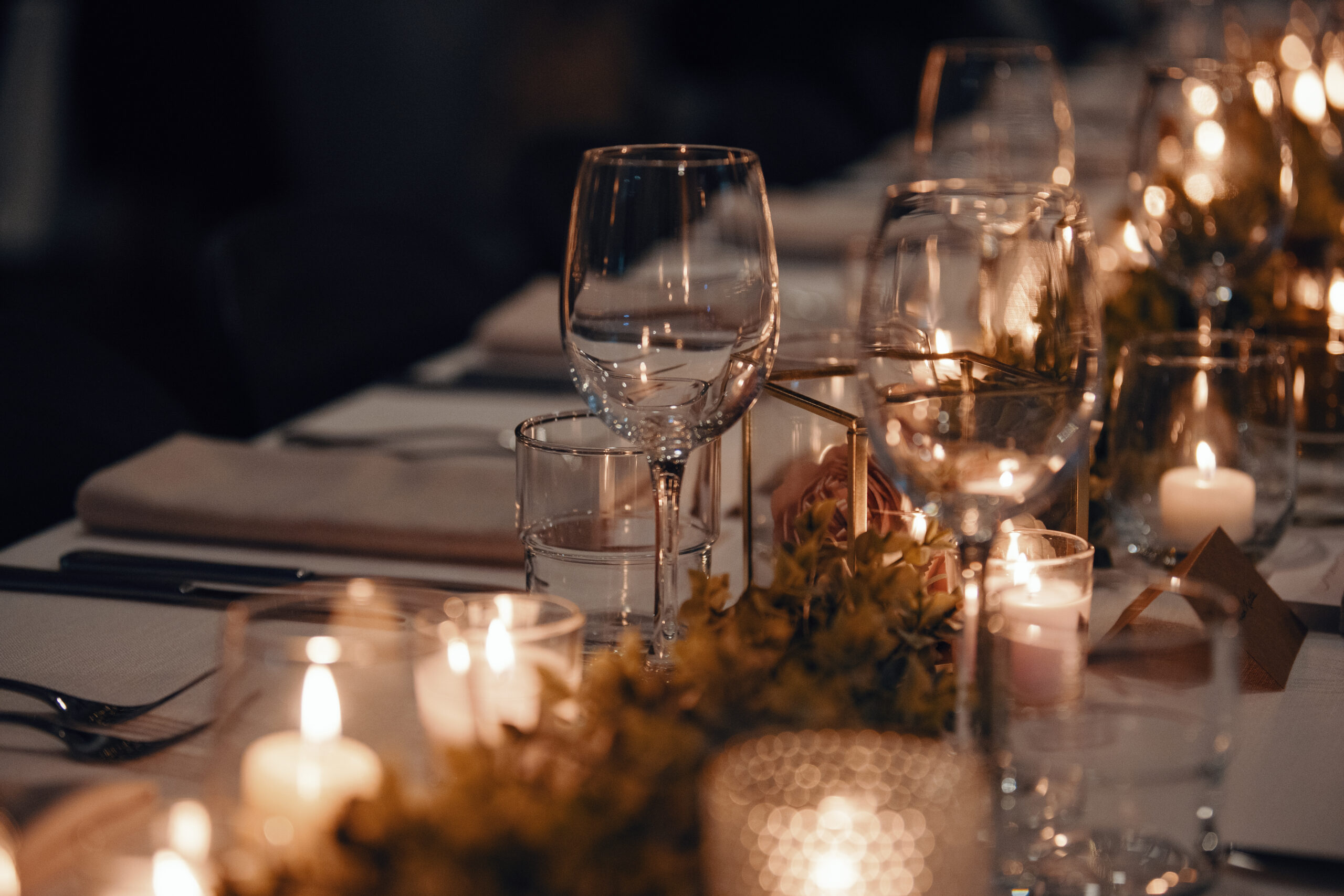 Candlelight glowing across a styled wedding table inside a historic reception room