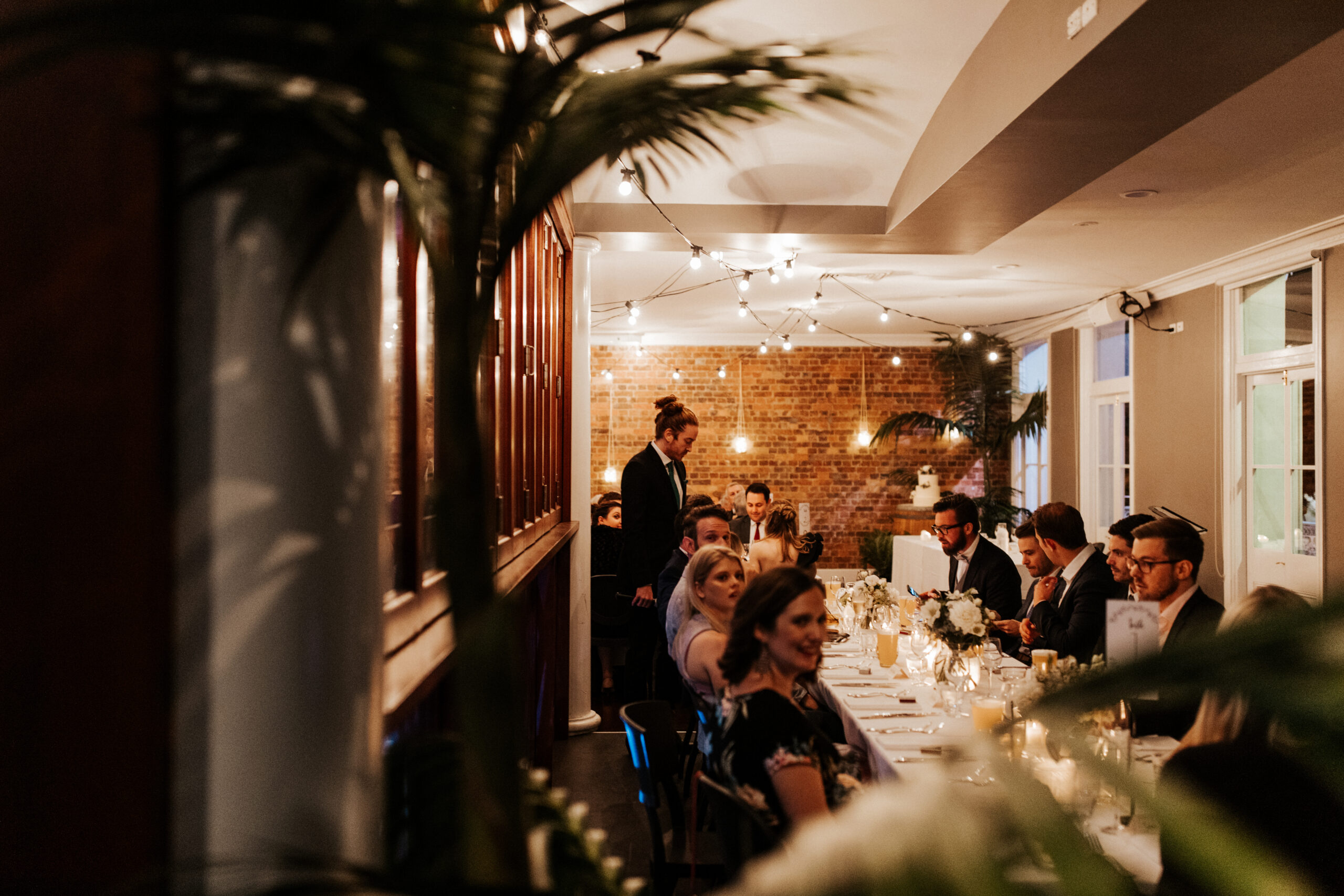Wedding guests sharing conversation in a warmly styled reception corner