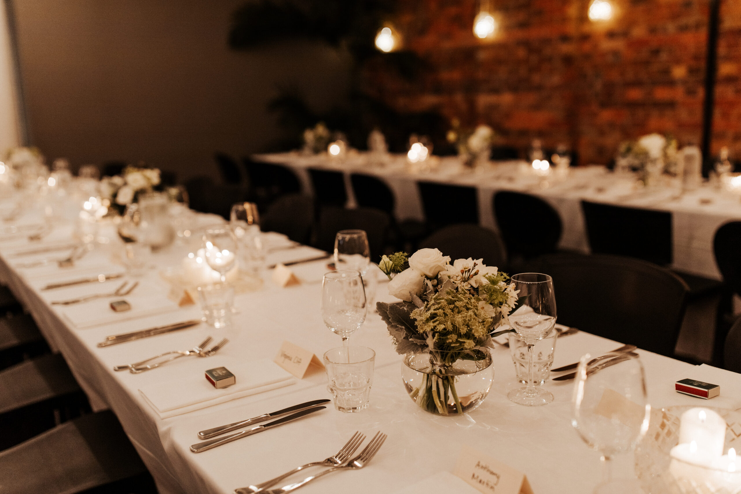 Neutral linen wedding table styled against exposed brick inside Transcontinental Hotel