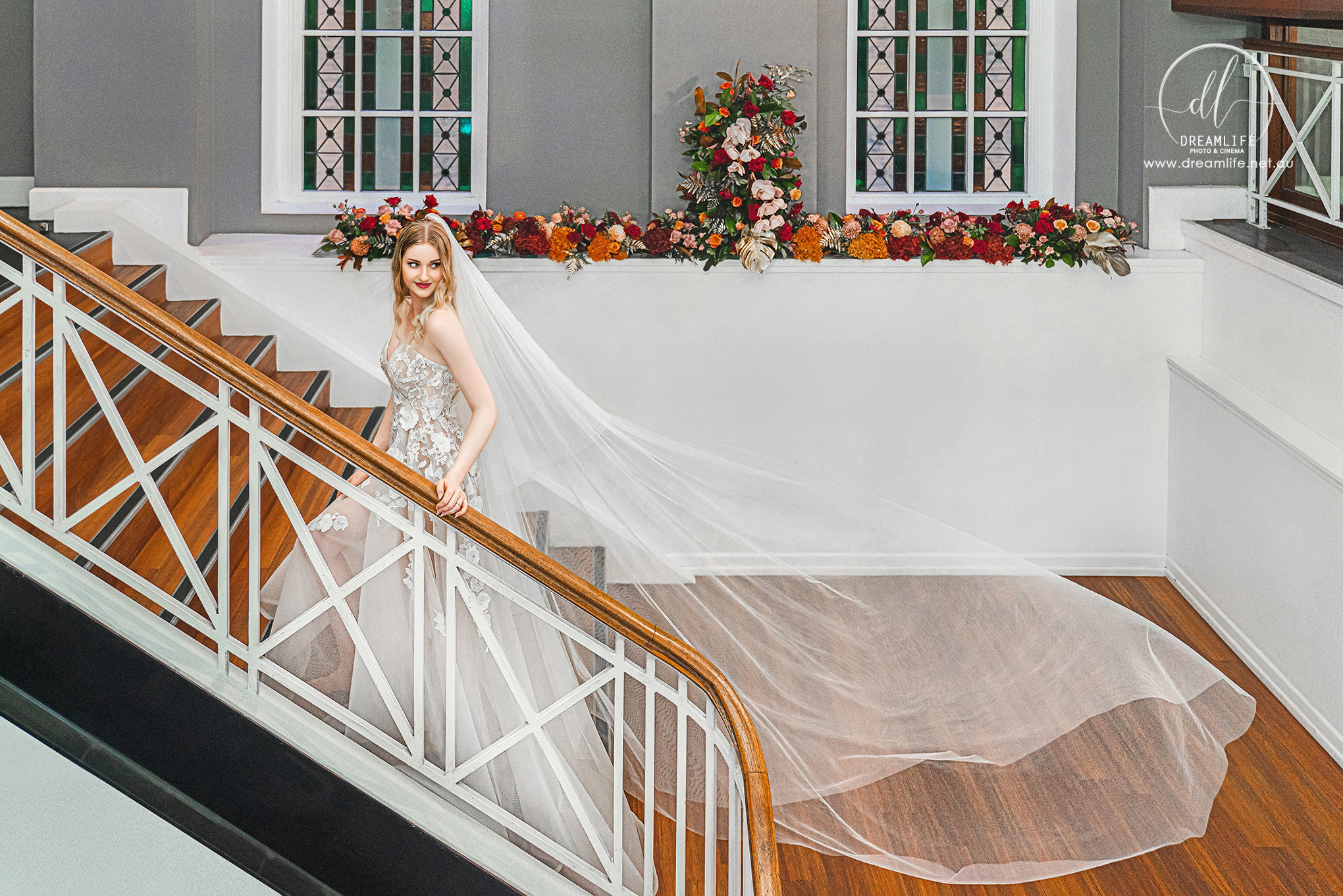 Wedding portrait beside original staircase styling with soft seasonal flowers