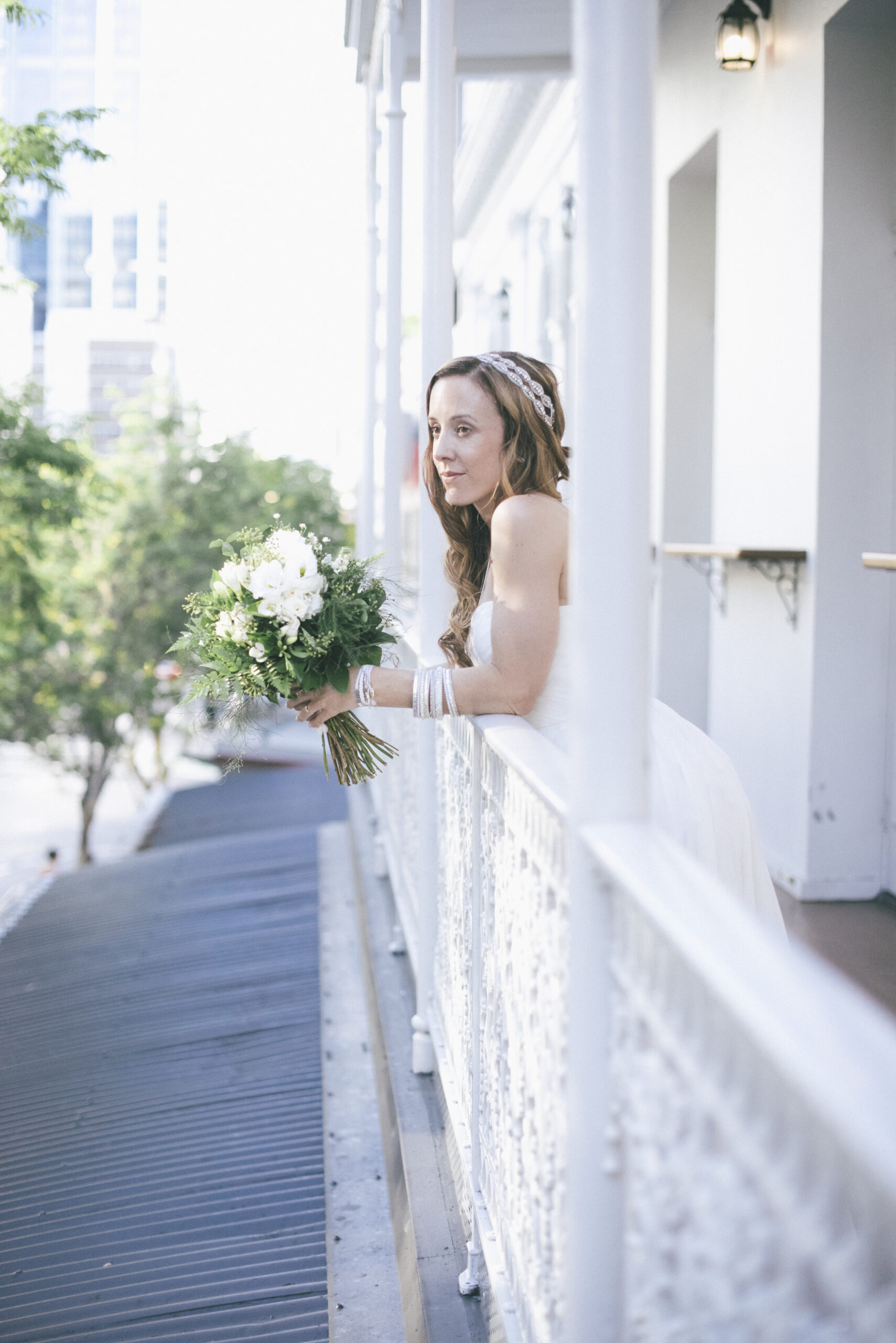 Bride holding white flowers on the balcony during a bright Brisbane wedding day